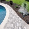 Pool pavers with brown rubber mulch along the edge