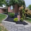 Black Rubber Mulch in Stone Retaining Wall