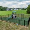 Playground with black fence and green rubber mulch