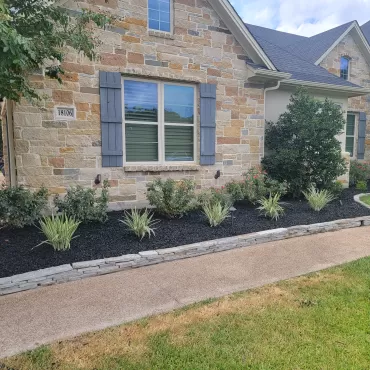 Black Landscaping Rubber Mulch in Front of Stone House