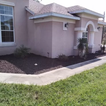 Rubber mulch adjacent to house and sidewalk