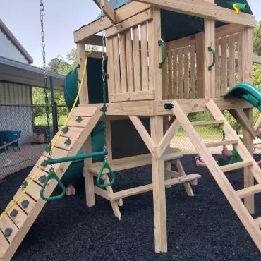 Black rubber mulch under wood playground