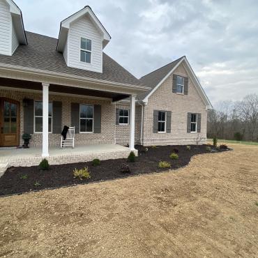 Home with Brown Rubber Mulch Landscaping Front of house with brown rubber mulch garden beds