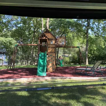 Grandkids playground with red rubber mulch