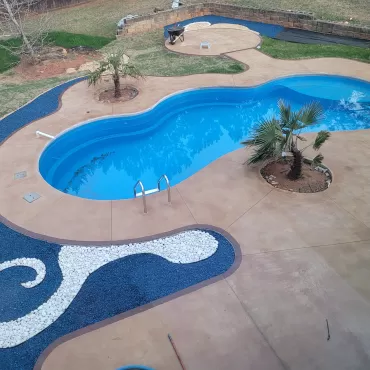 Pool with blue rubber mulch and white stone waves