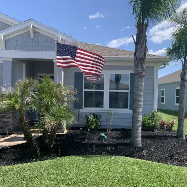 Front bed residential landscaping with black rubber mulch
