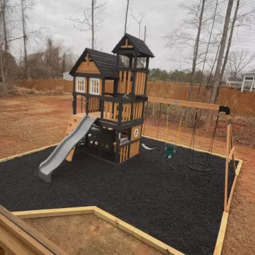Playground with black rubber mulch ground cover