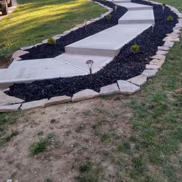 Walkway flanked with black rubber mulch