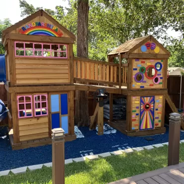 Blue rubber mulch ground cover under a colorful playground