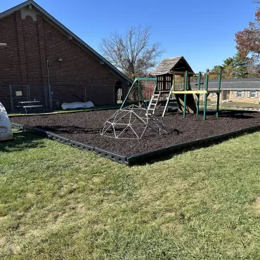 Playground Ground Surface of Brown Rubber Mulch and DuraTimber Borders 