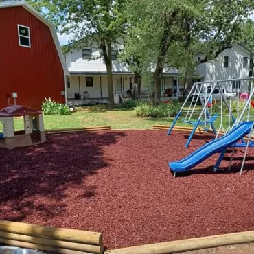 Playground with Rubber Mulch Near Barn