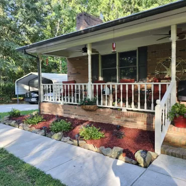 Red rubber mulch landscaping in front of patio