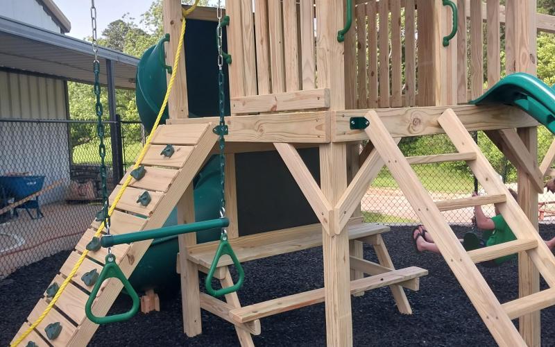Black rubber mulch under wood playground