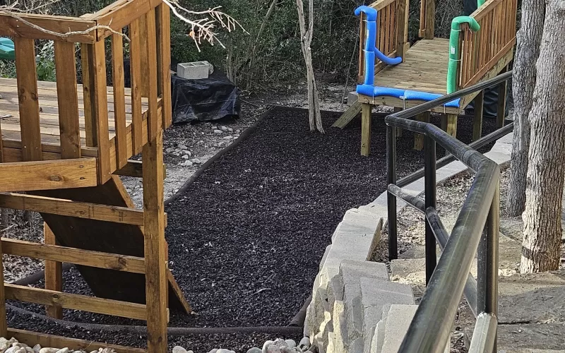 Brown rubber mulch and borders under a zip line