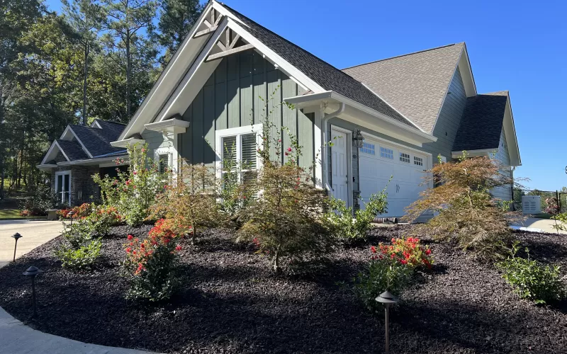 Stunning Green House With Brown Rubber Mulch Landscaping
