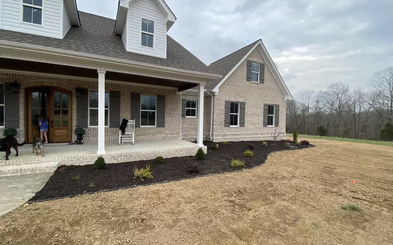 Front of house with brown rubber mulch garden beds