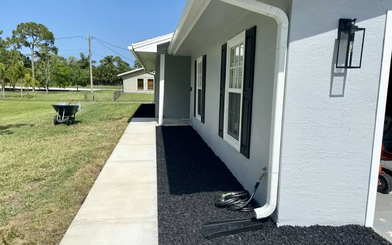 Black rubber mulch in beds in front of house