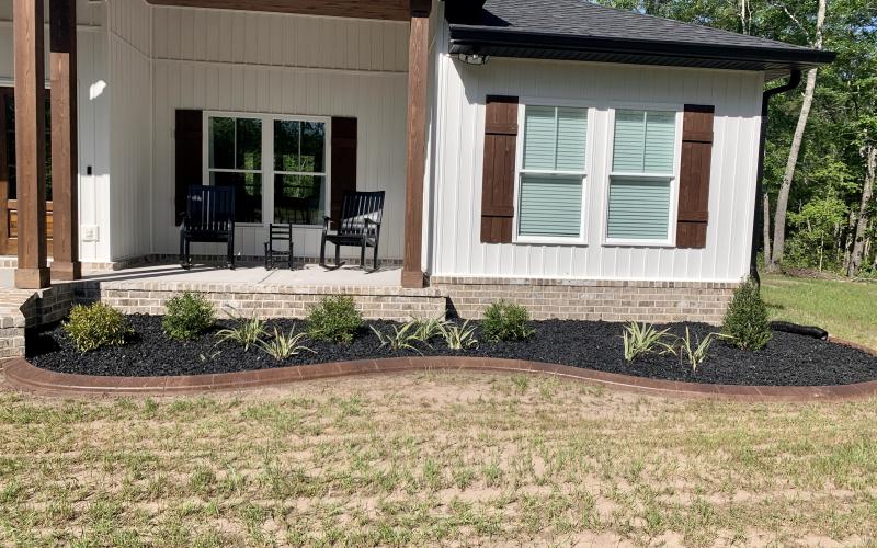 Front of house with black rubber mulch garden bed