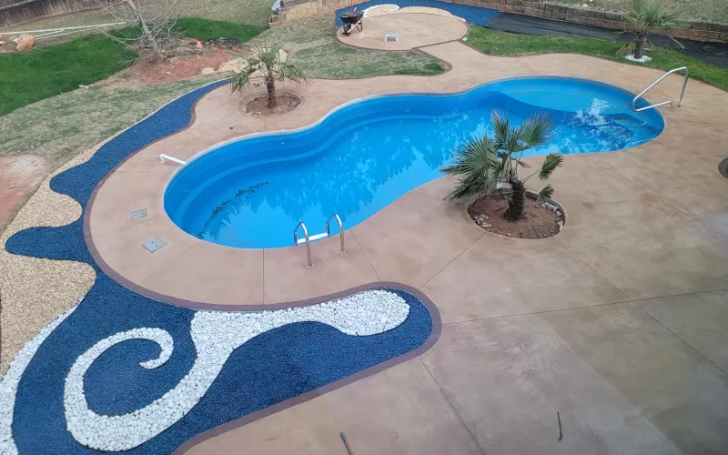 Pool with blue rubber mulch and white stone waves