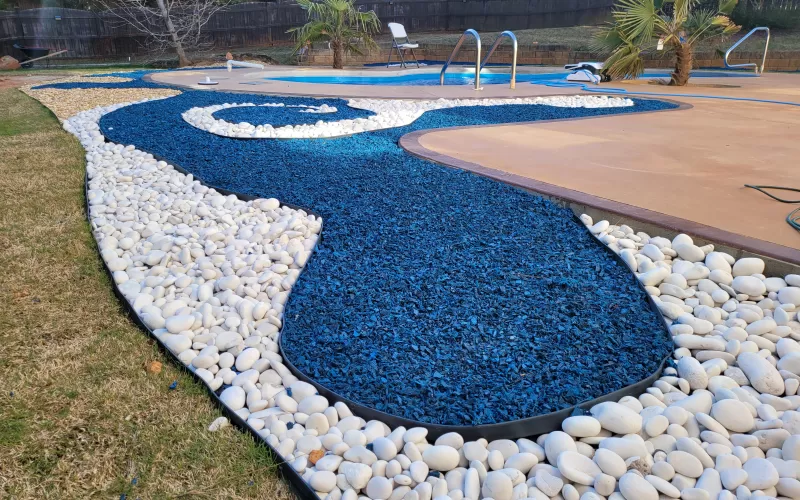 Blue rubber mulch and stone landscaping design