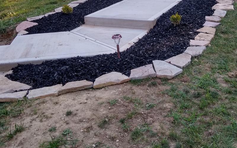 Walkway flanked with black rubber mulch