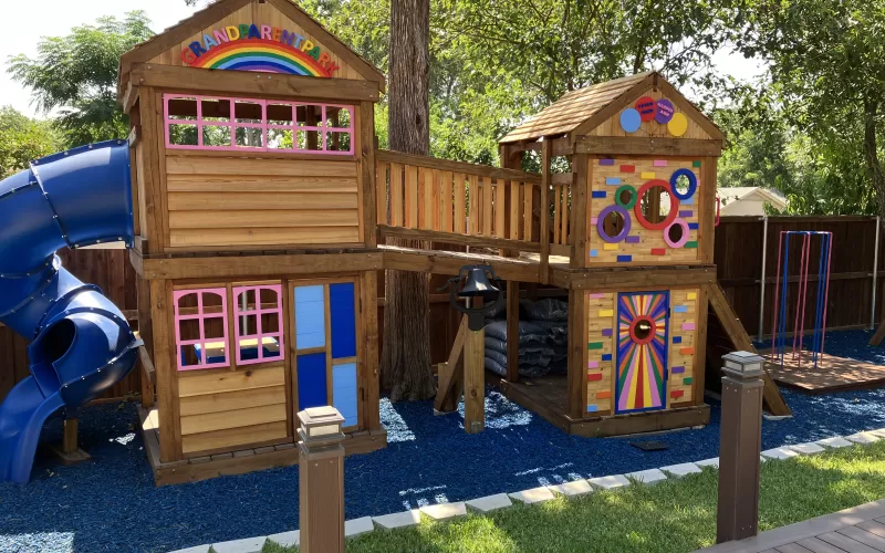 Blue rubber mulch ground cover under a colorful playground