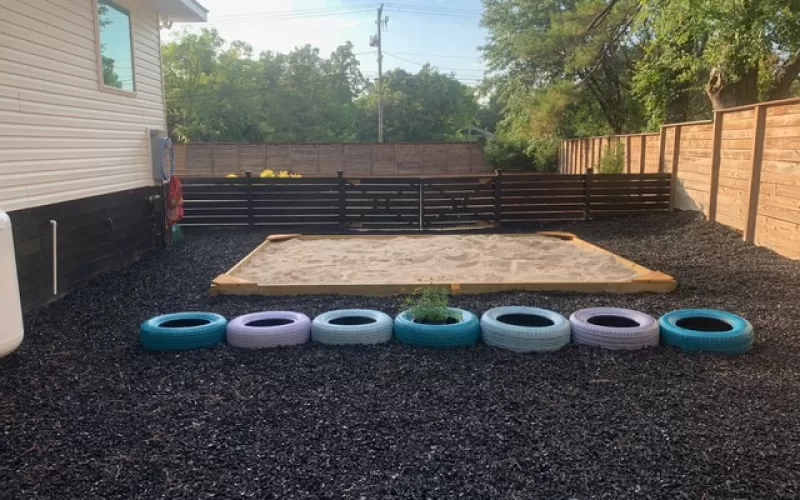Sandbox with rubber mulch surrounding