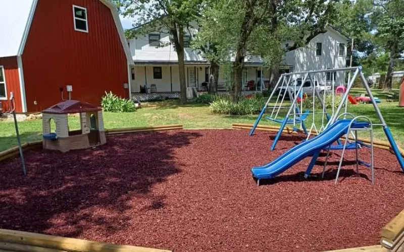 Playground with Rubber Mulch Near Barn