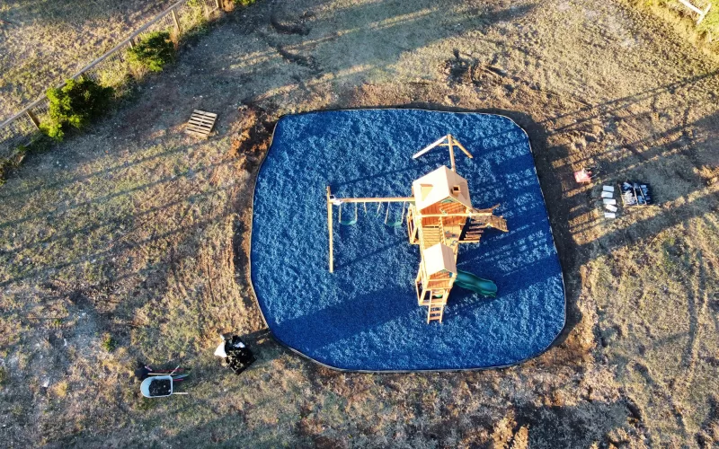 Playground with blue rubber mulch ground cover