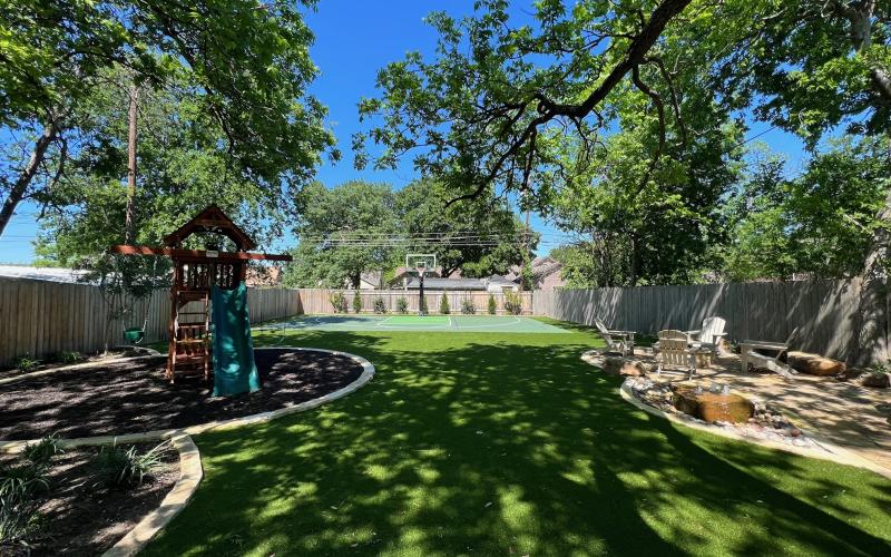 Yard with rubber mulch playground and basketball court and sitting area