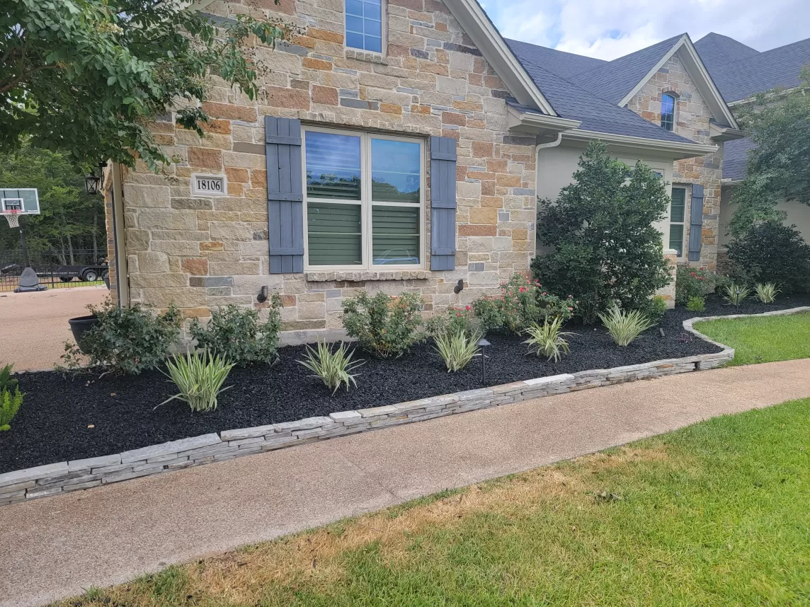 Black Landscaping Rubber Mulch in Front of Stone House
