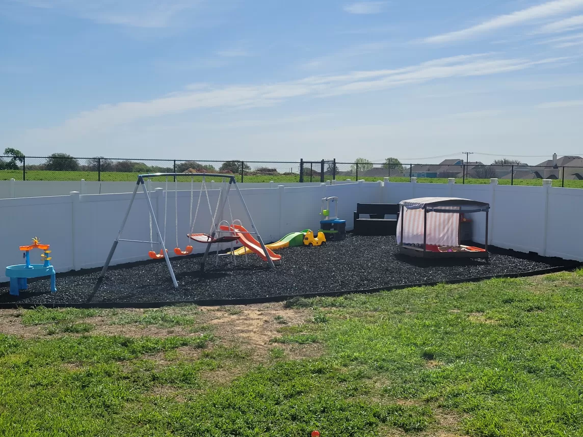 Black Rubber Mulch Playground in Corner of Backyard
