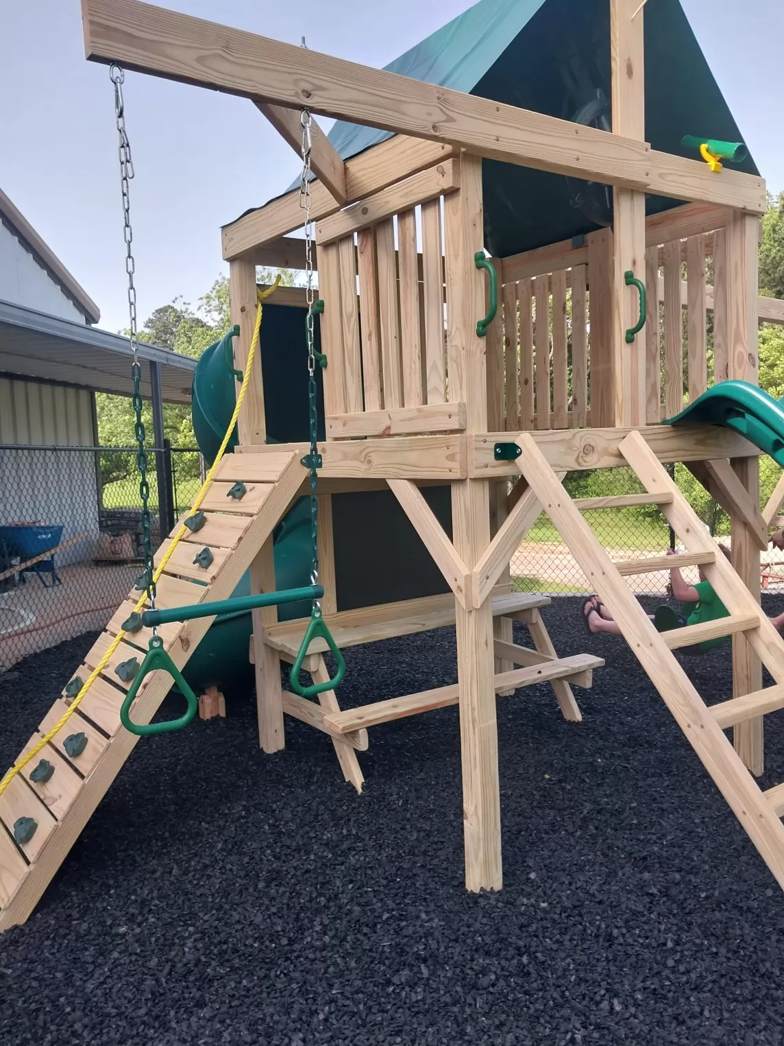Black rubber mulch under wood playground