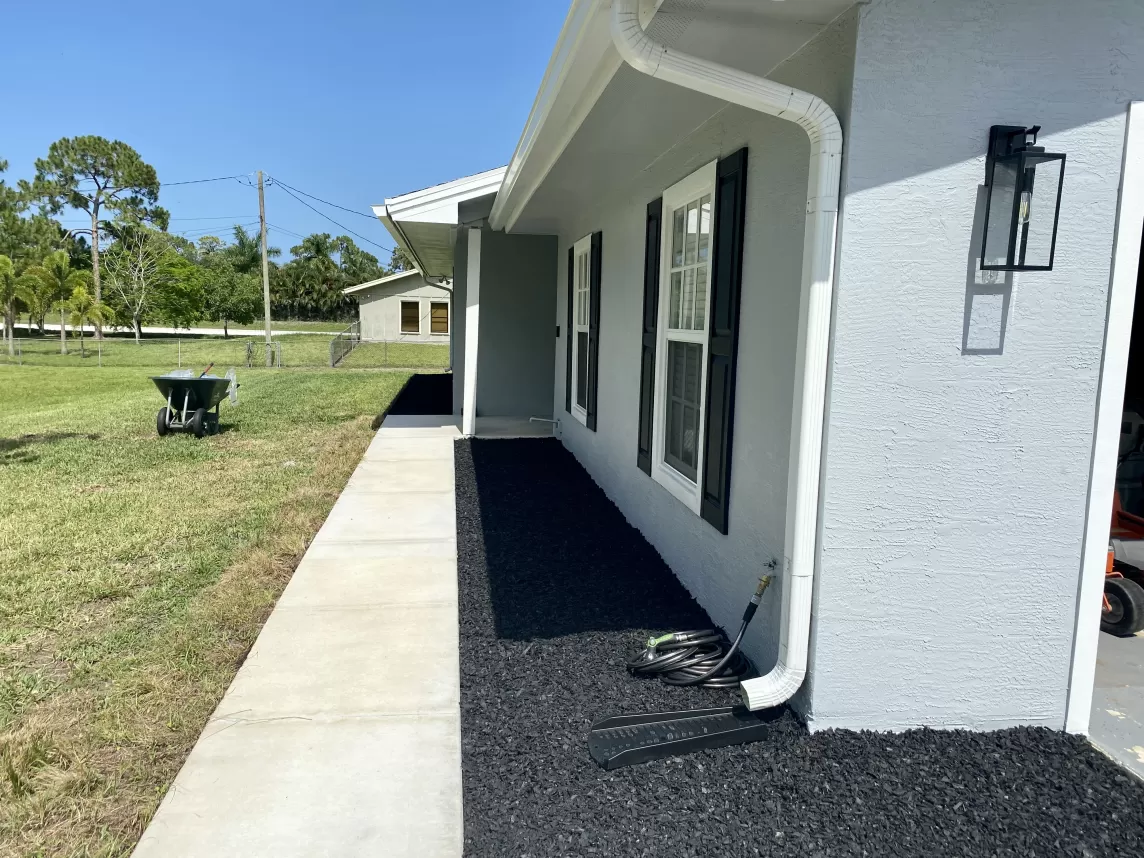 Black rubber mulch in beds in front of house