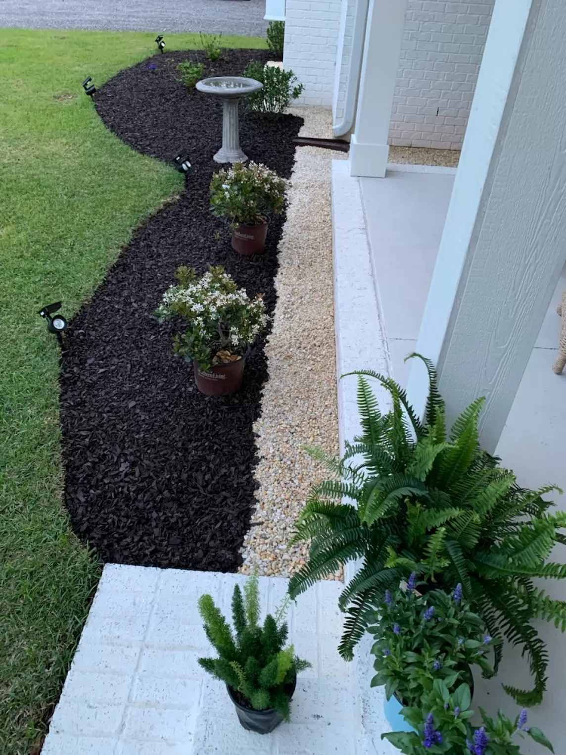 Brown rubber mulch landscape bed in front of home entrance.