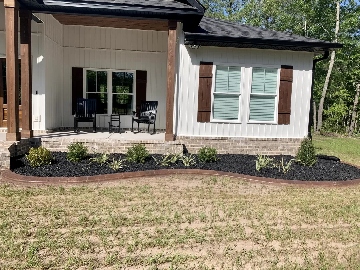 Front of house with black rubber mulch garden bed