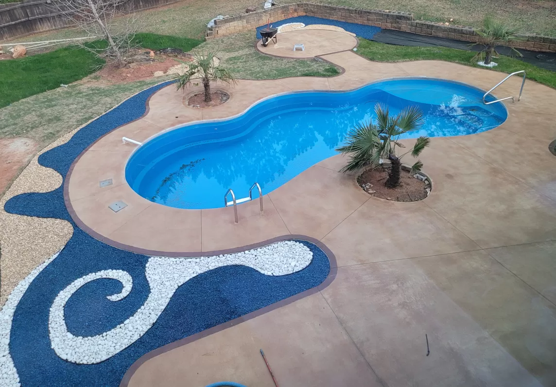 Pool with blue rubber mulch and white stone waves