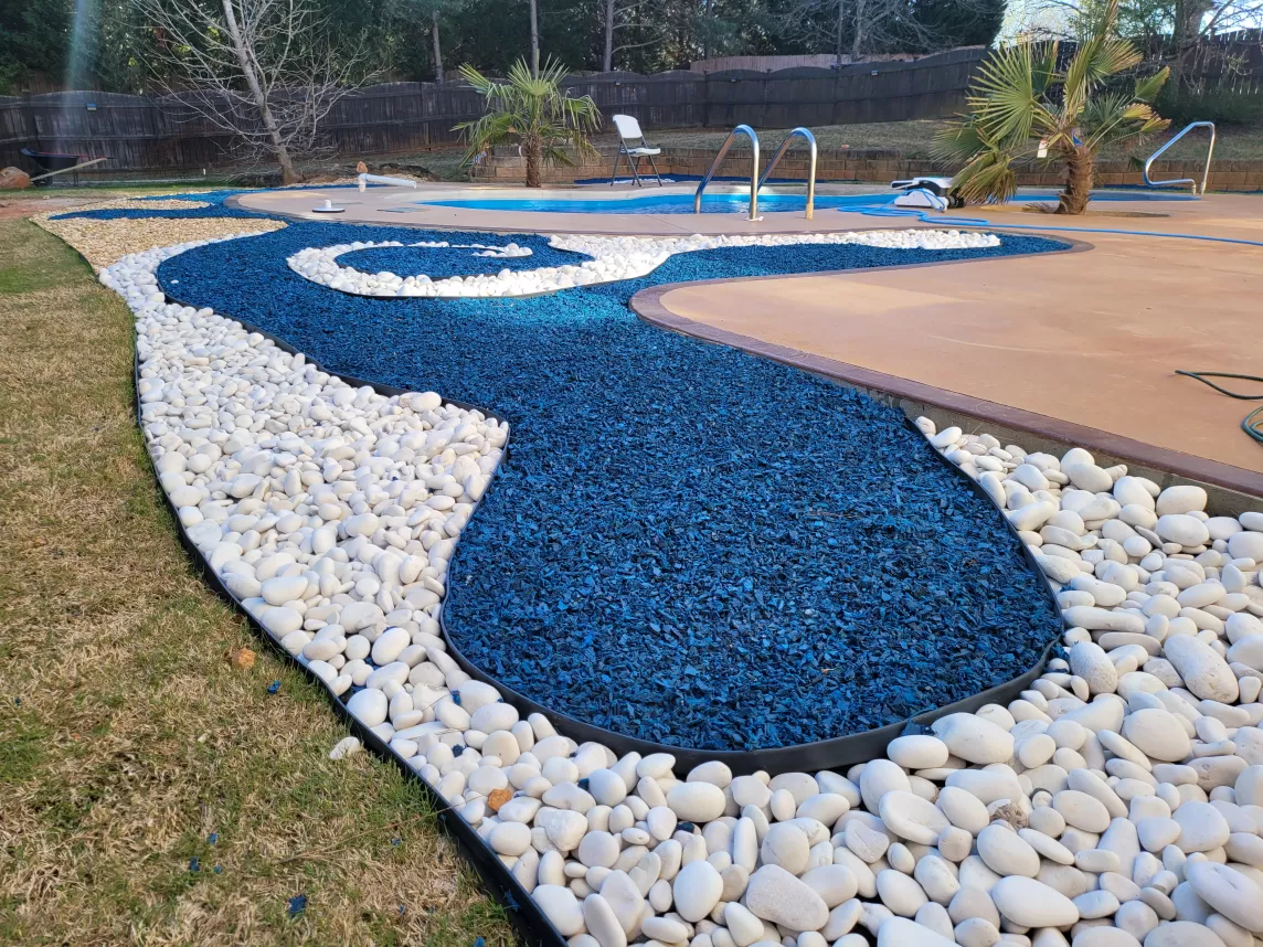 Blue rubber mulch and stone landscaping design