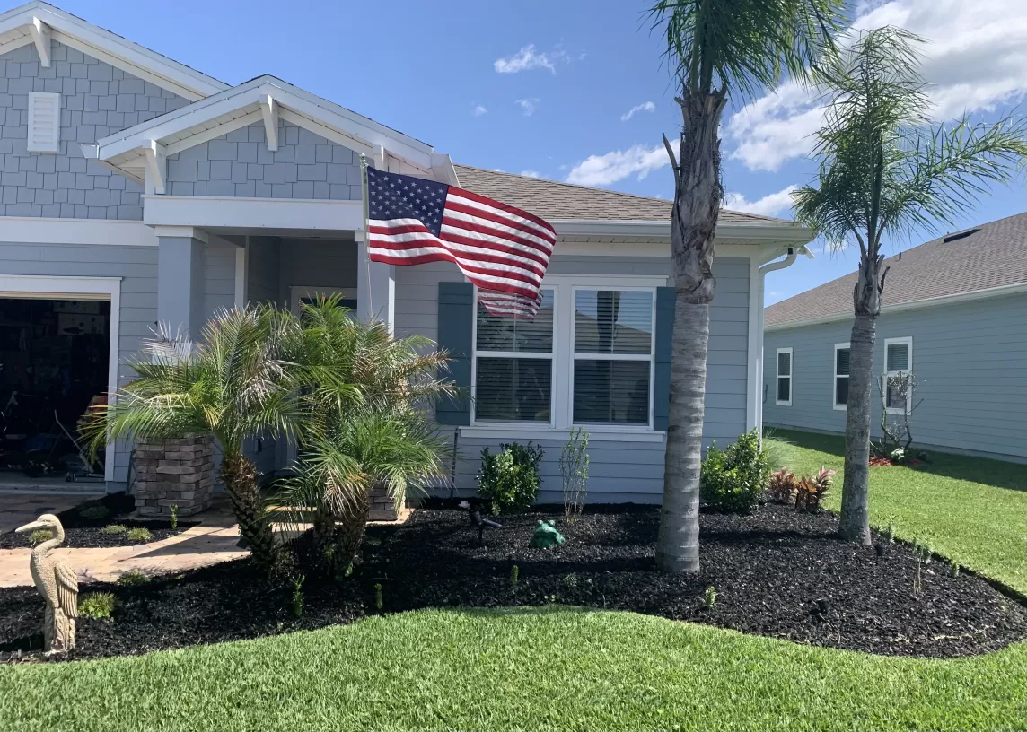Front bed residential landscaping with black rubber mulch