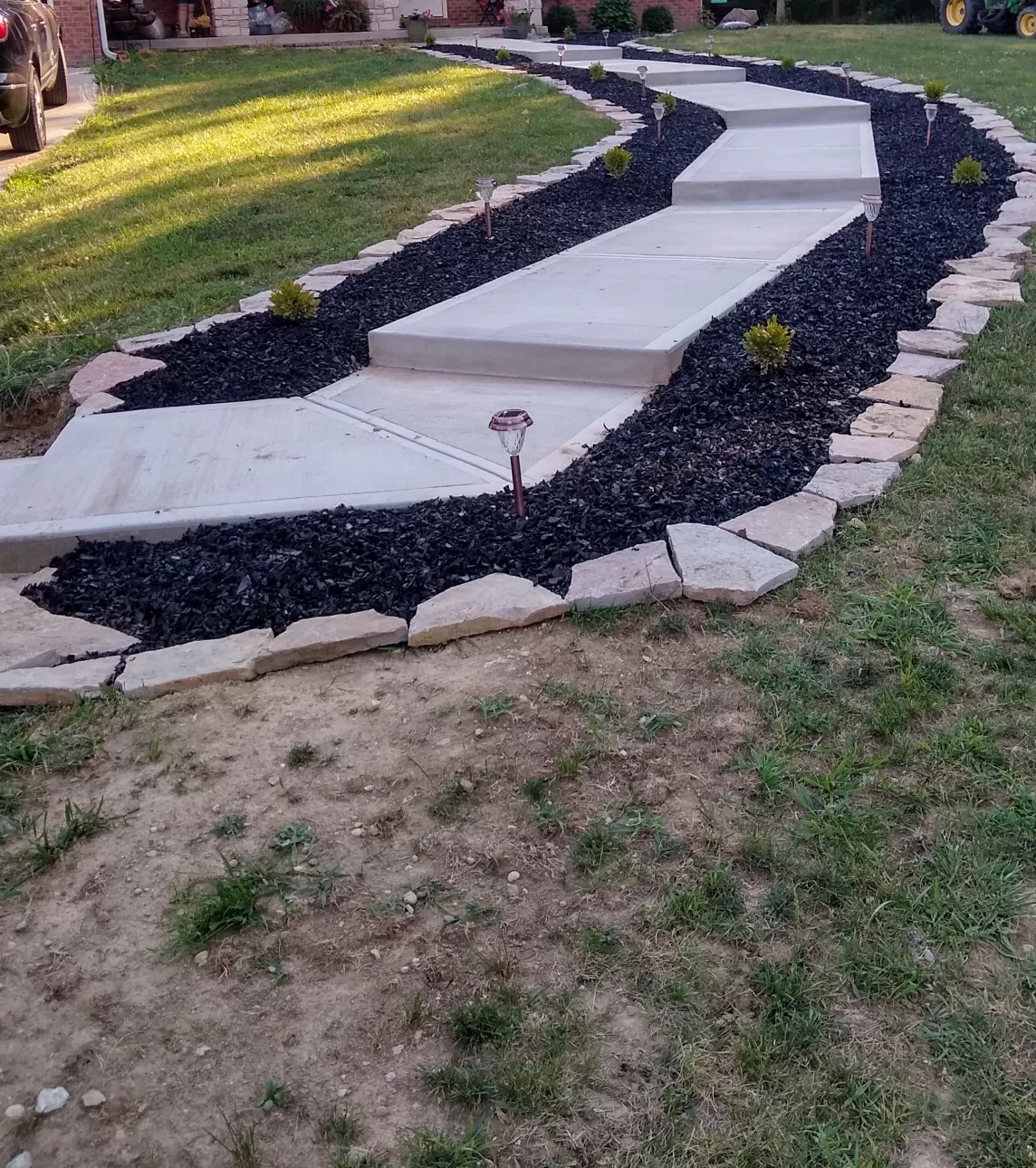 Walkway flanked with black rubber mulch