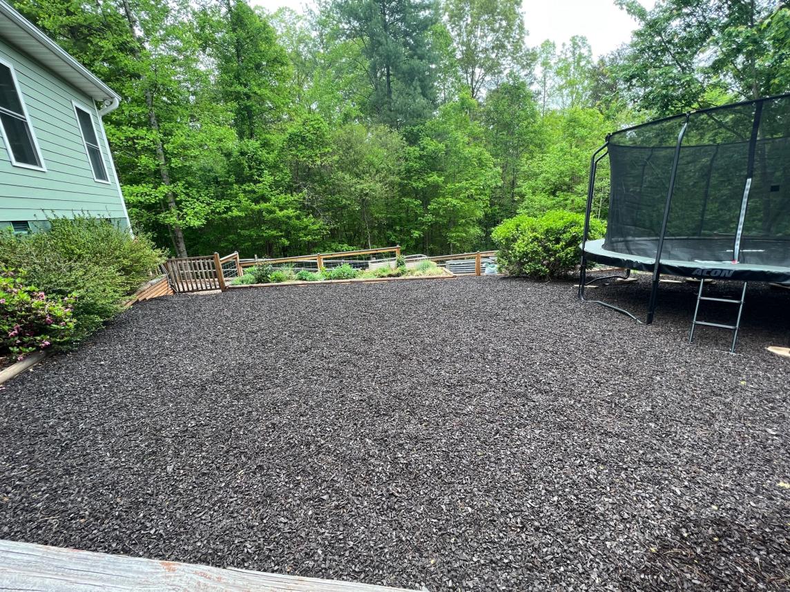 Play zone with trampoline and brown rubber mulch