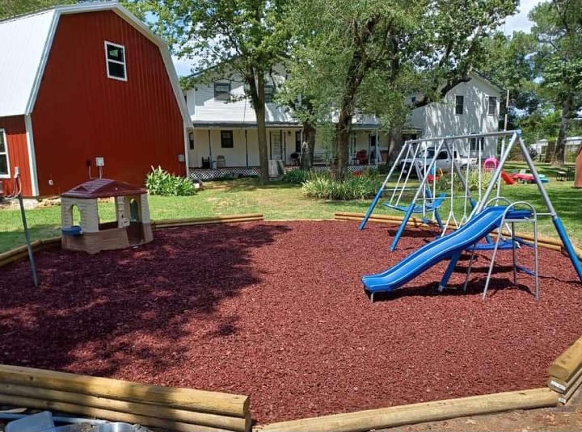 Playground with Rubber Mulch Near Barn