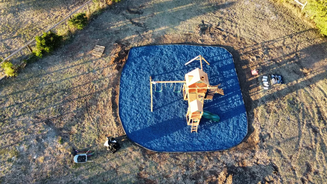 Playground with blue rubber mulch ground cover