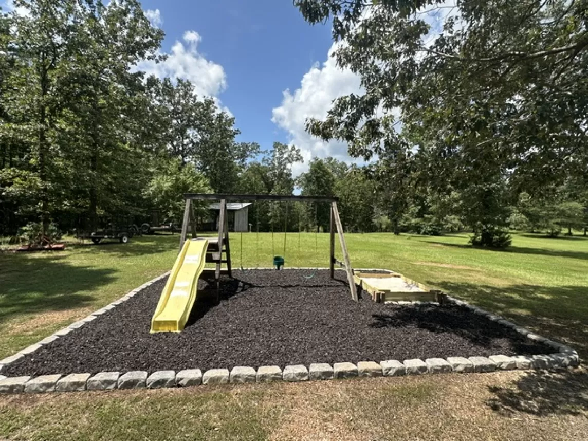Brown Rubber Mulch Play Area with Stone Border