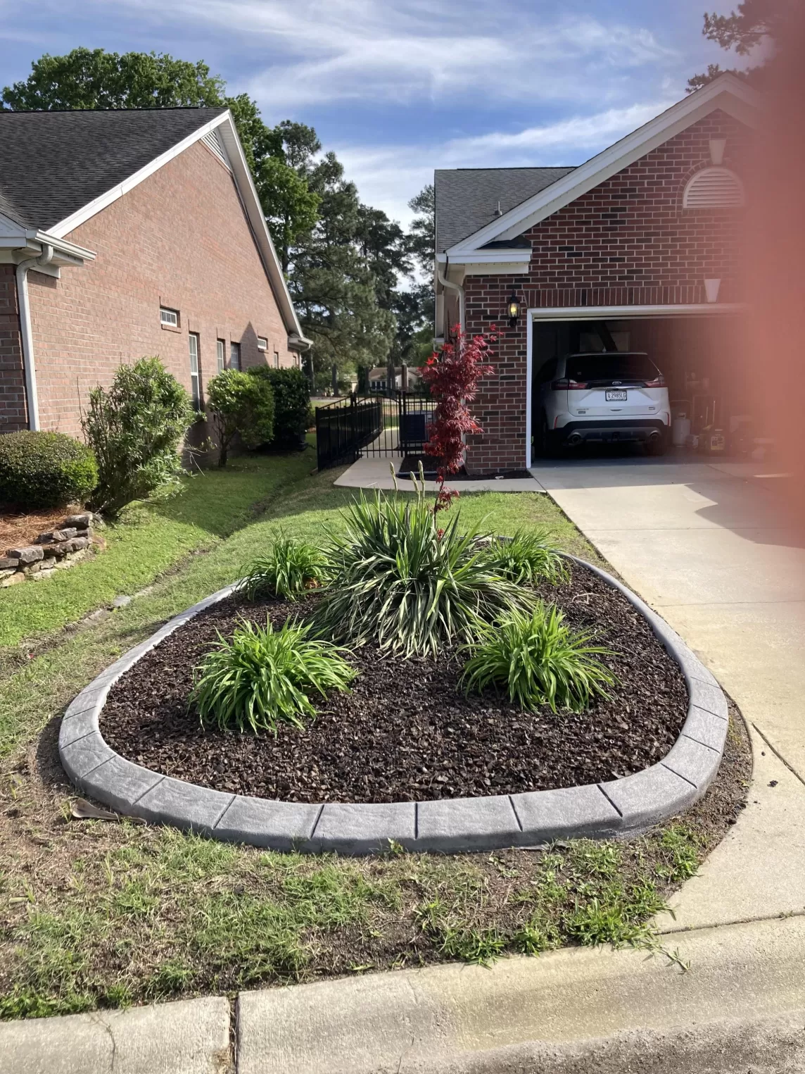 Rubber mulch in a landscape island bed surrounded by rock