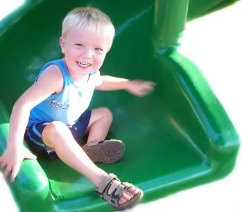 Happy child sliding down a slide.